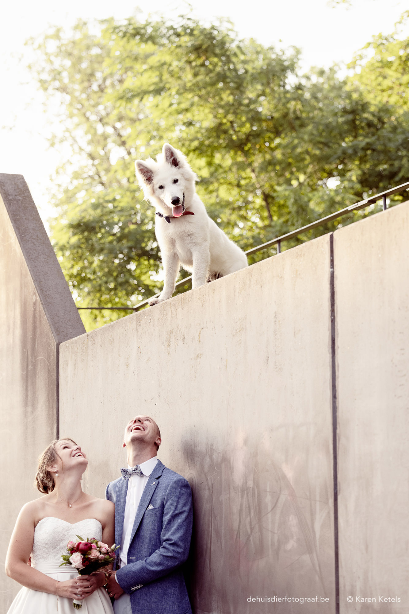 Portret van een huwelijkskoppel en hun witte herder-pup door De Huisdierfotograaf